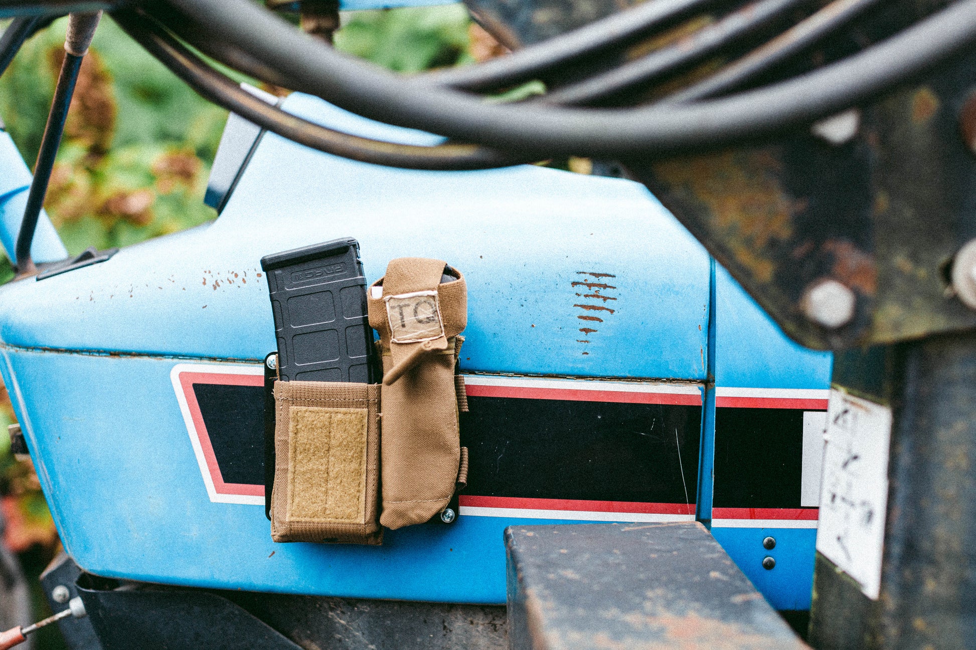 MOLLE panel mounted to the inside of a tractor cab holding a tan GP pouch for quick-access storage.