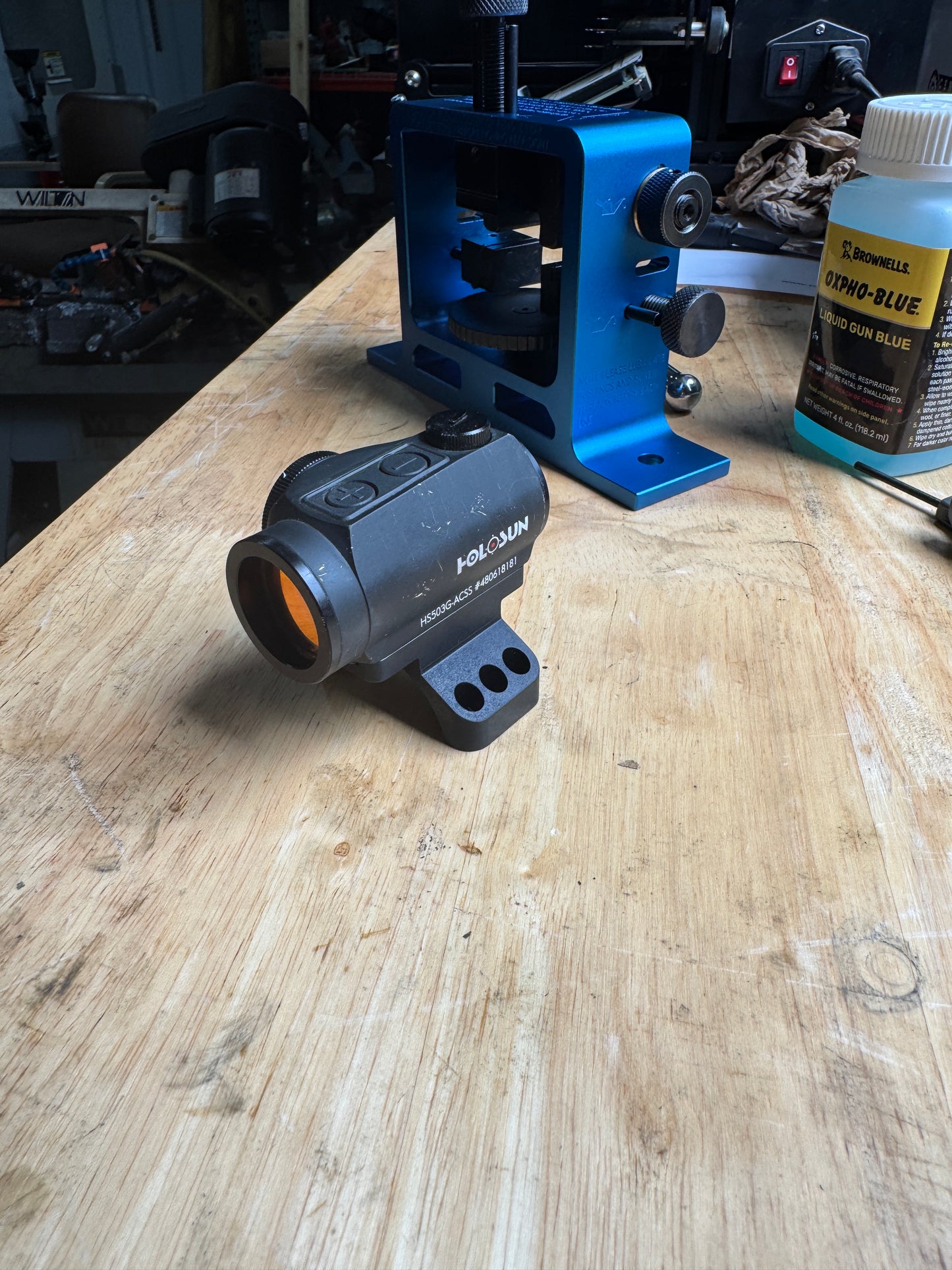 Aimpoint Micro red dot mounted on Homestead Defense 35mm piggyback scope ring cap adapter during test fit on the workbench