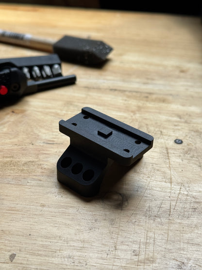 Badger Ordnance 35mm Aimpoint Micro scope ring cap adapter – CNC-machined black anodized billet aluminum mount on a workbench.