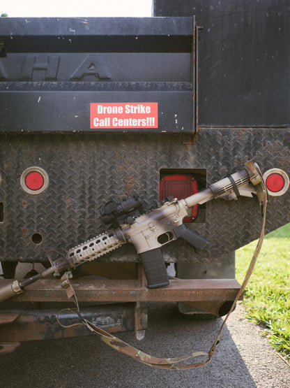 Drone Strike Call Centers bumper sticker applied to the back of a trailer next to metal equipment.