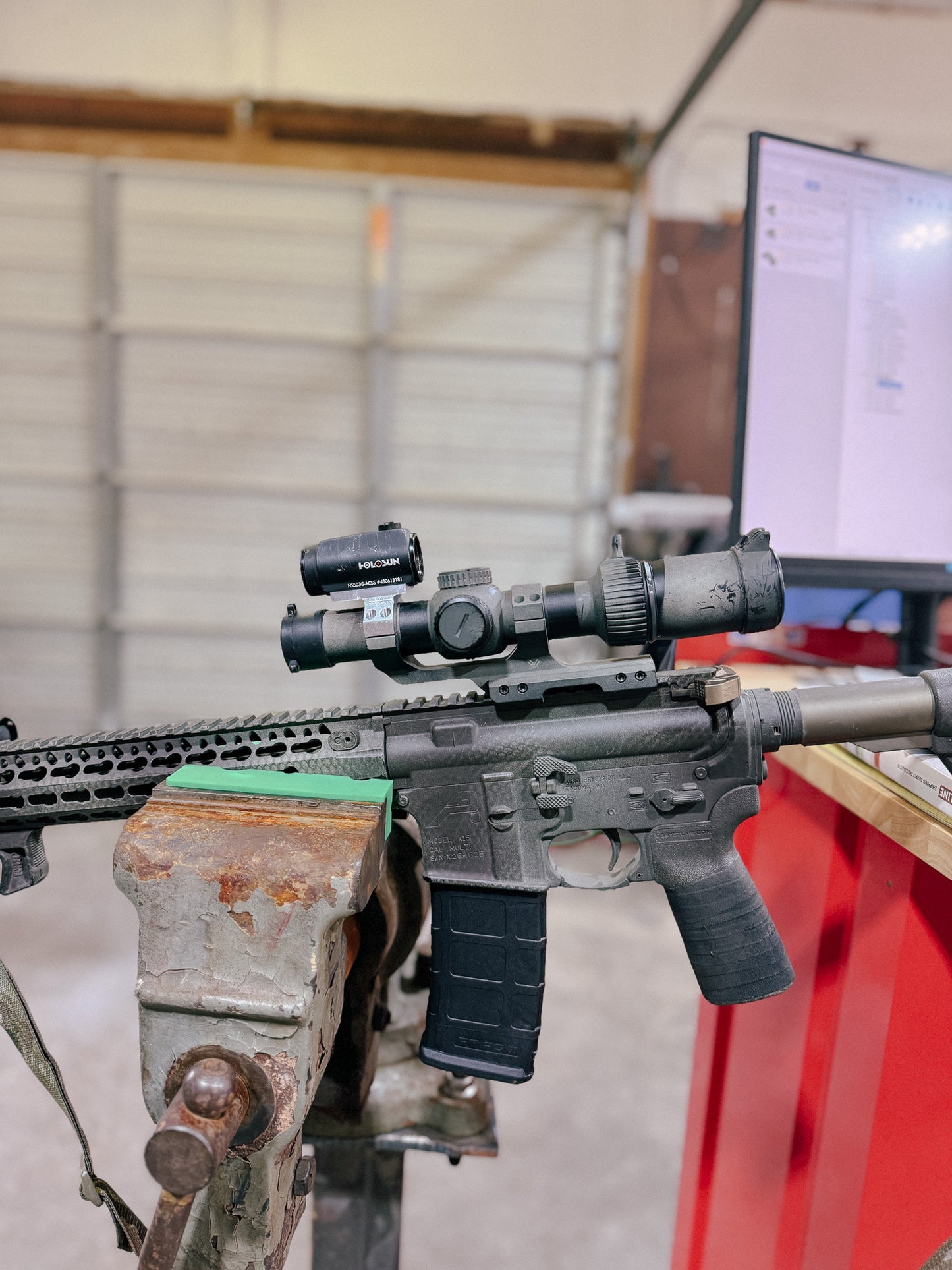 Aimpoint Micro piggybacked on top of Vortex 30mm cantilever mount installed on an AR-15 rifle.