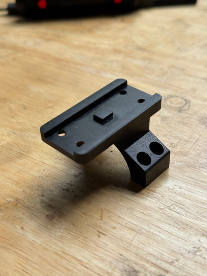 Vortex 30mm Aimpoint Micro piggyback scope ring adapter machined from anodized billet aluminum on a wooden workbench.