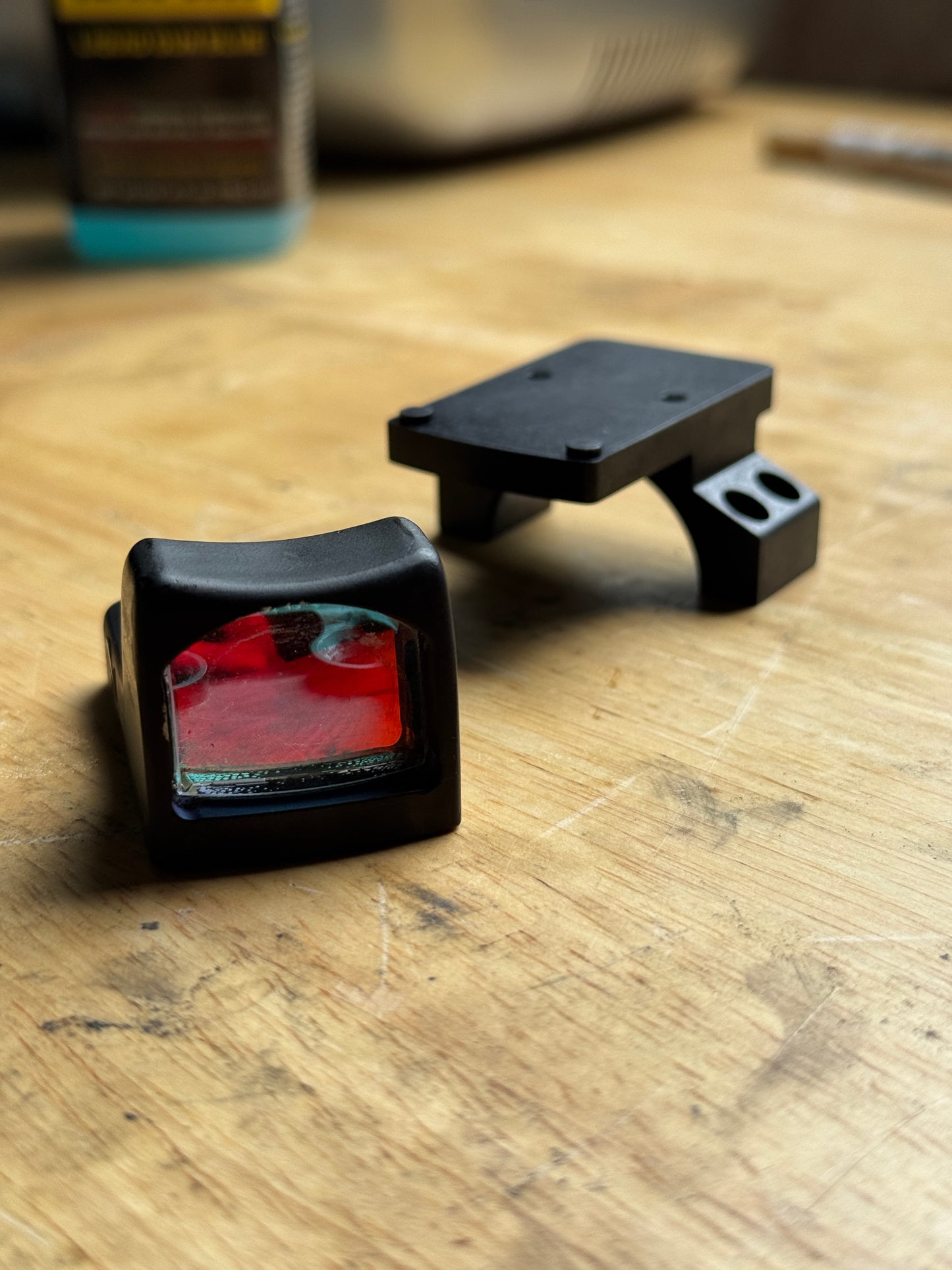 Vortex 30mm RMR piggyback scope ring adapter with RMR optic displayed on a wooden workbench.